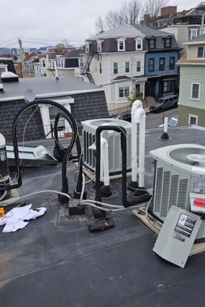 Rooftop HVAC units and piping on apartment roof