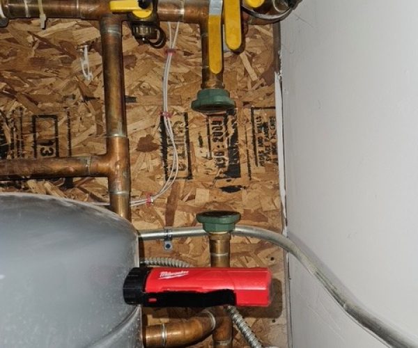 Copper plumbing pipes with valves and red tool Copper plumbing pipes with valves and red tool