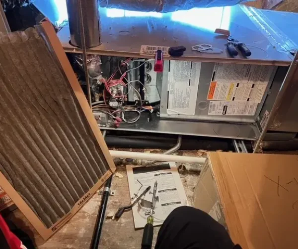 A person working on an air conditioner unit. A person working on an air conditioner unit.