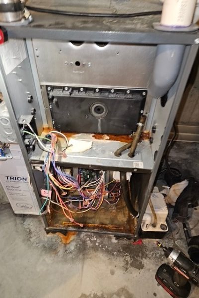 Rusty open furnace with exposed wiring