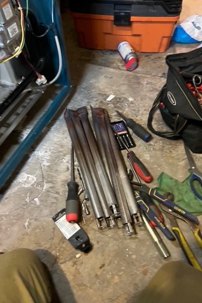 Toolbag, screwdrivers, and metal rods on floor