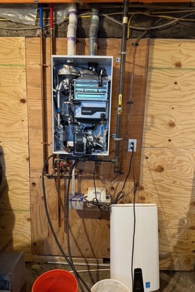 A wall mounted electrical box with wires hanging from it.