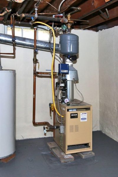 A room with two water heaters and a boiler.
