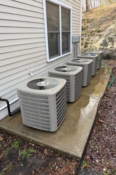 Four outdoor air conditioning units on pad