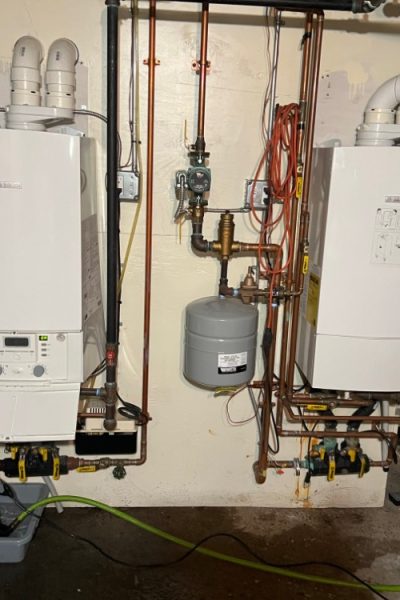 Two wall-mounted boilers with copper piping