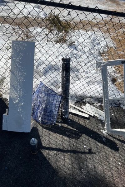 Discarded window frames and mesh by fence